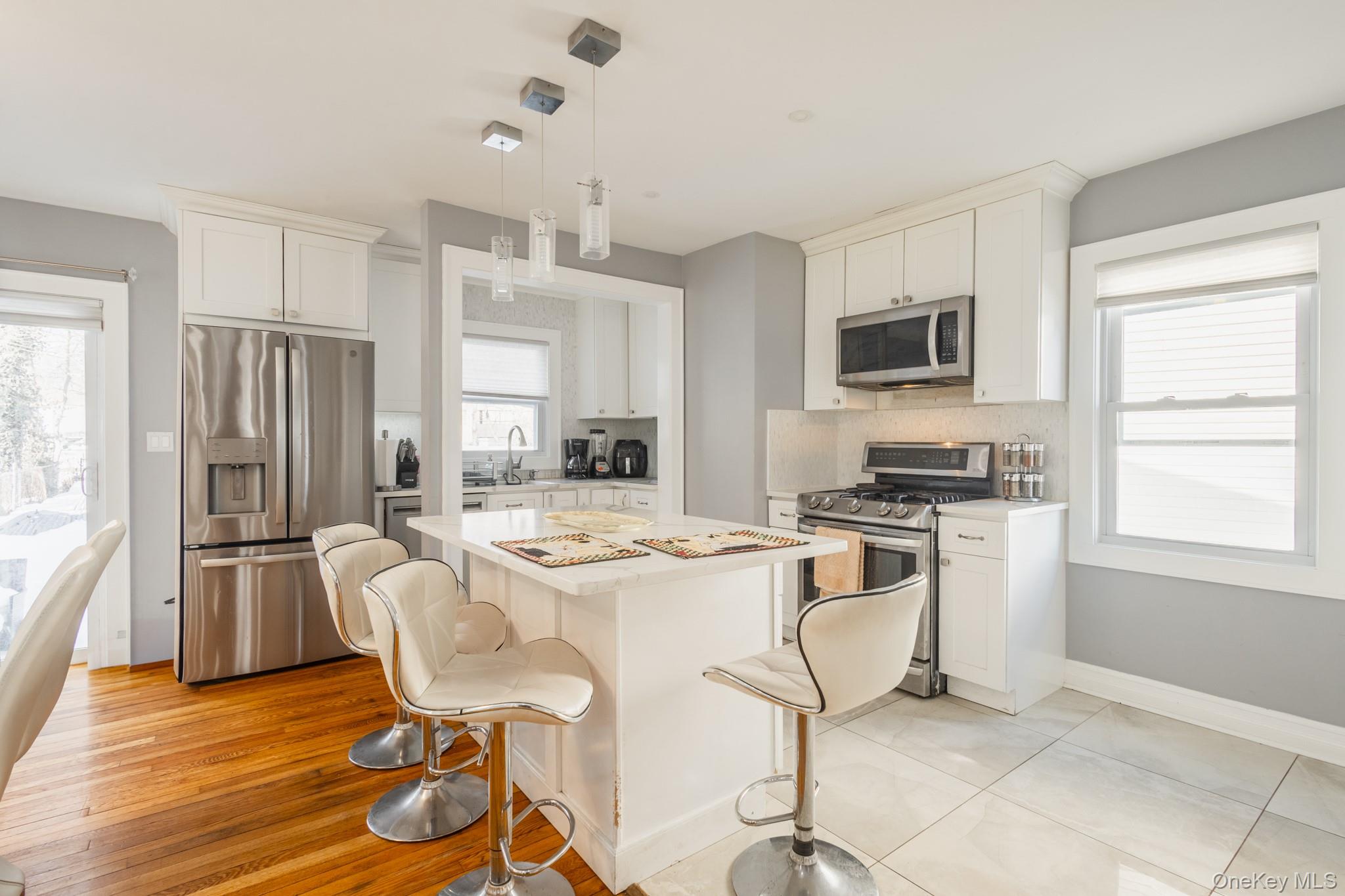 50 Acorn Terrace New Rochelle, NY 10801 - Photo 8 of 27 a kitchen with stainless steel appliances kitchen island granite countertop a refrigerator a stove a microwave oven a sink dishwasher and white cabinets with wooden floor