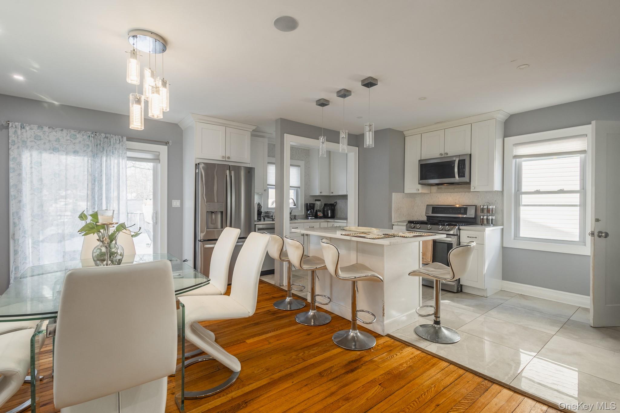 50 Acorn Terrace New Rochelle, NY 10801 - Photo 9 of 27 a kitchen with stainless steel appliances granite countertop a stove top oven a sink dishwasher a dining table and chairs with wooden floor