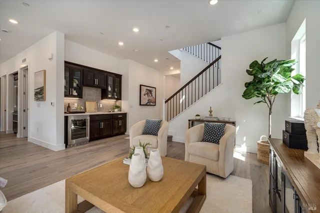 a living room with furniture potted plant and kitchen view