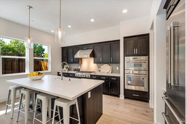 a kitchen that has a lot of cabinets in it and wooden floors