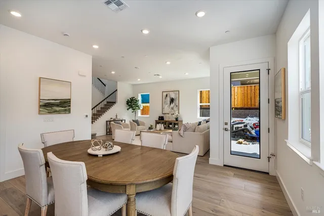a view of a dining room and livingroom with furniture wooden floor a chandelier
