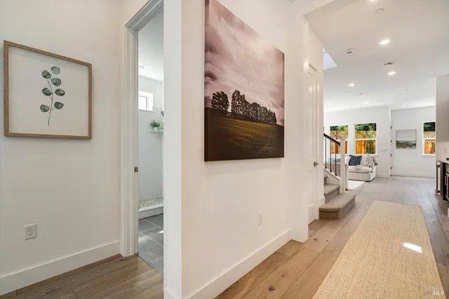 a view of a hallway with wooden floor and windows