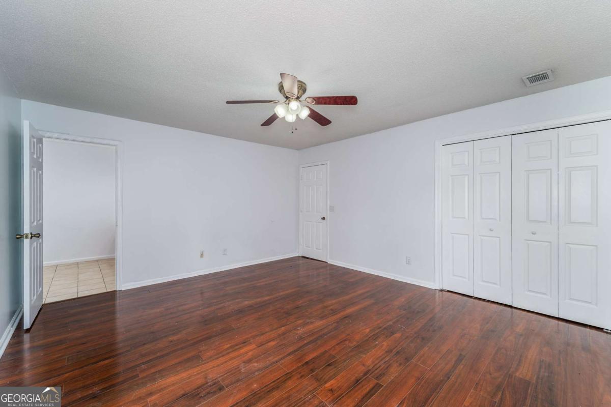 301 Ridge Lane Douglas, GA 31533 - Photo 16 of 26 a view of an empty room with wooden floor
