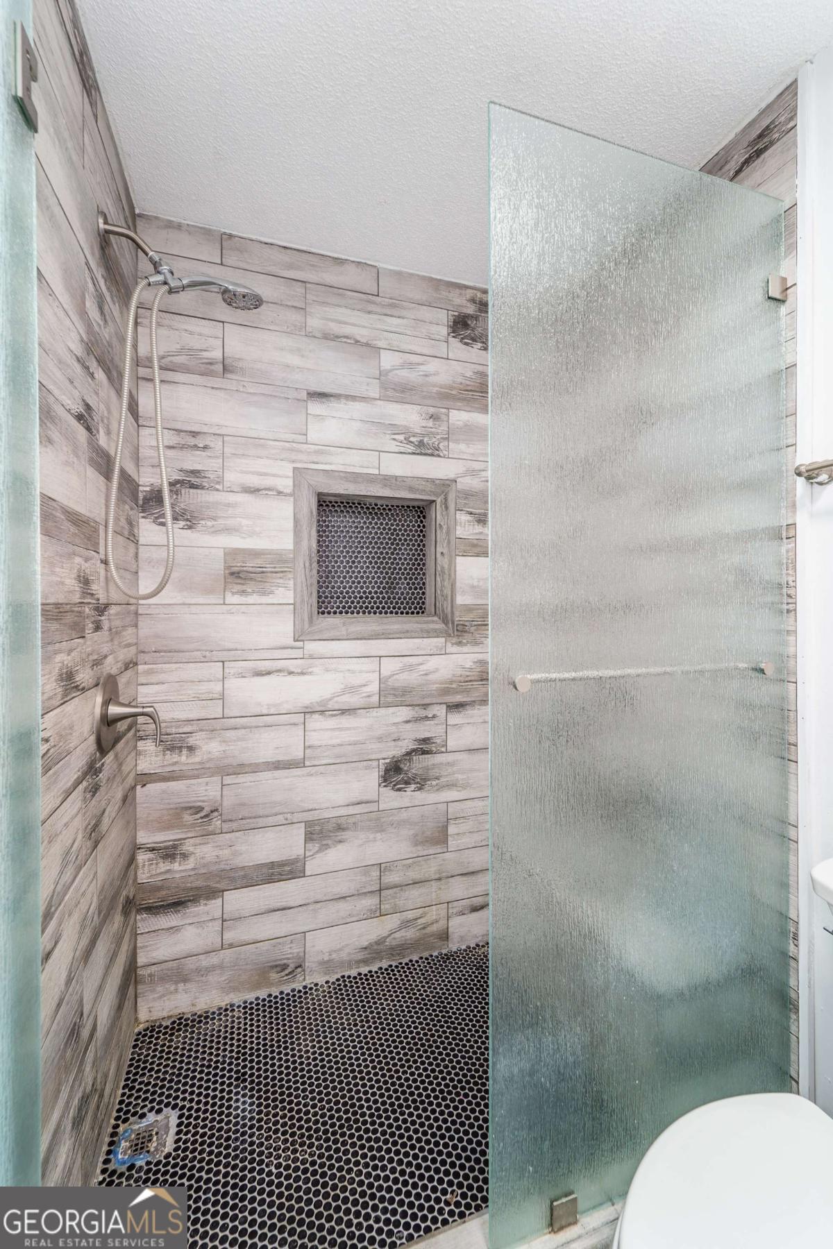 301 Ridge Lane Douglas, GA 31533 - Photo 17 of 26 a bathroom with a granite countertop toilet and a shower