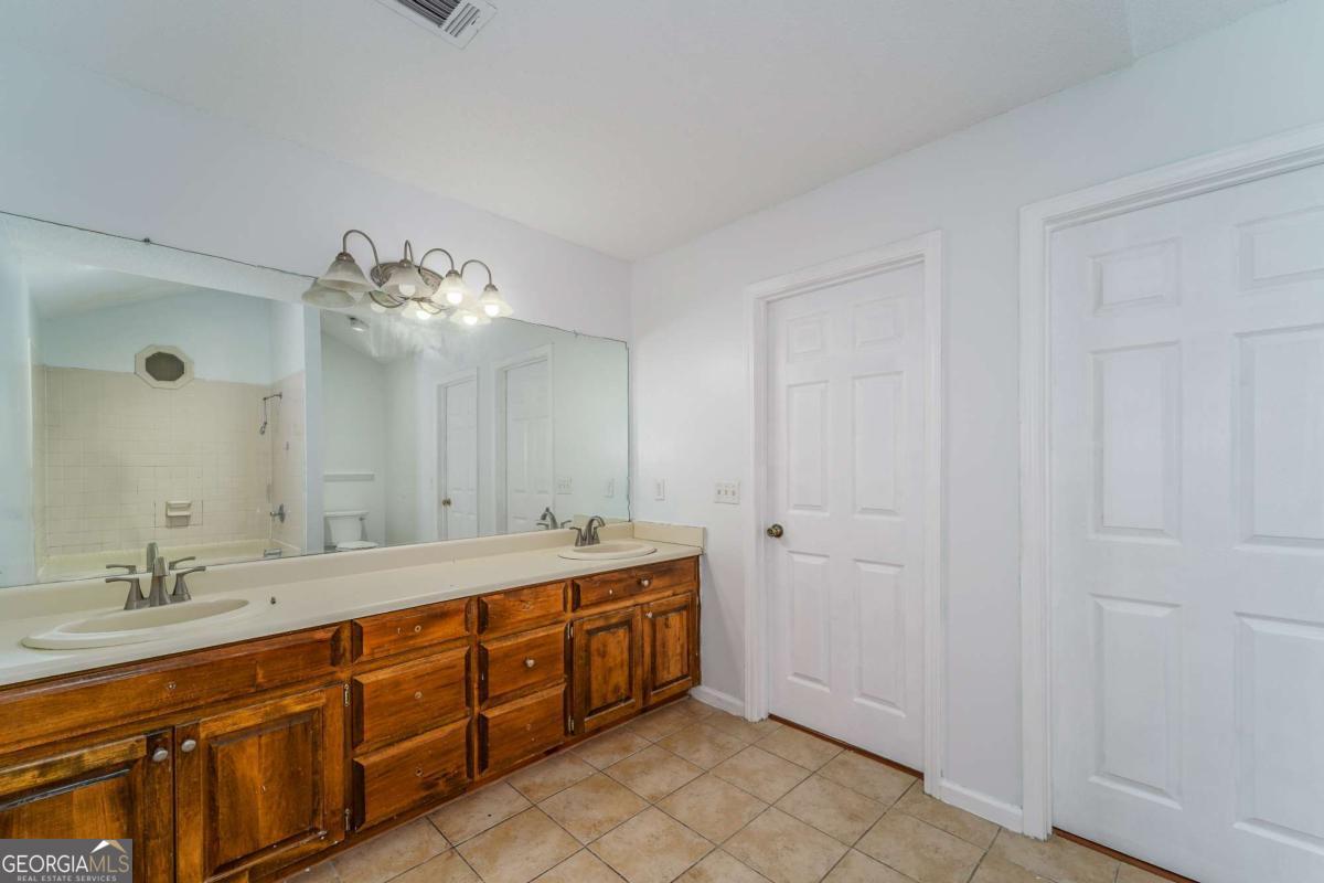 301 Ridge Lane Douglas, GA 31533 - Photo 19 of 26 a spacious bathroom with a double vanity sink and a mirror