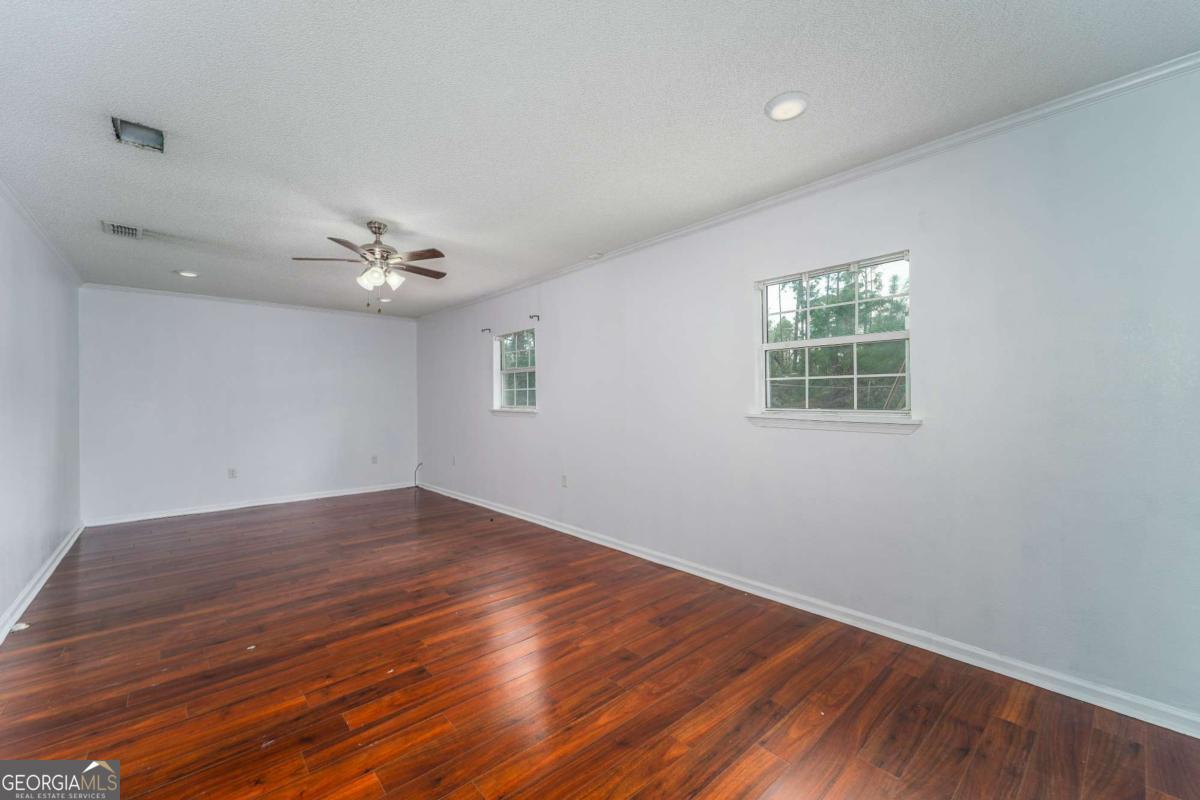 301 Ridge Lane Douglas, GA 31533 - Photo 25 of 26 a view of an empty room with wooden floor and a window
