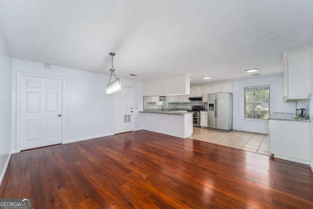 a view of an empty room with wooden floor