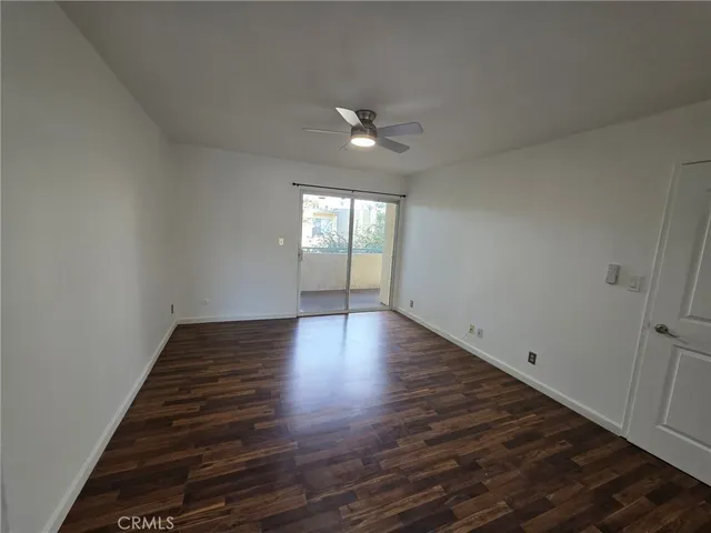 an empty room with wooden floor and natural light