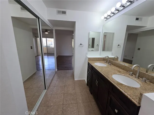 a spacious bathroom with a granite countertop sink a mirror and a shower