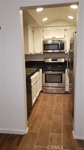 a kitchen with granite countertop a stove and a microwave