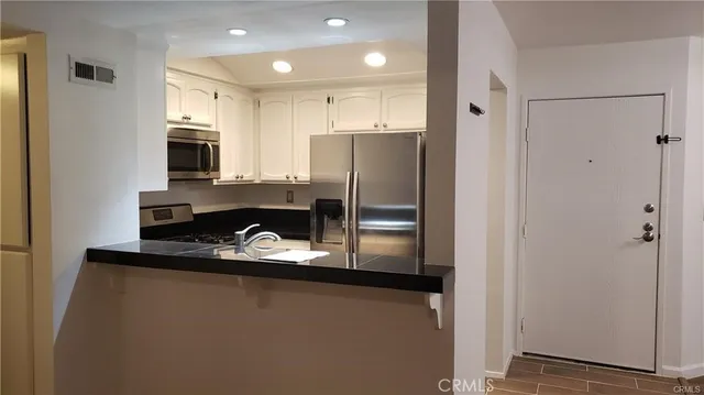 a kitchen with stainless steel appliances granite countertop a refrigerator and a stove