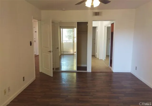 a view of a hallway with wooden floor and chandelier