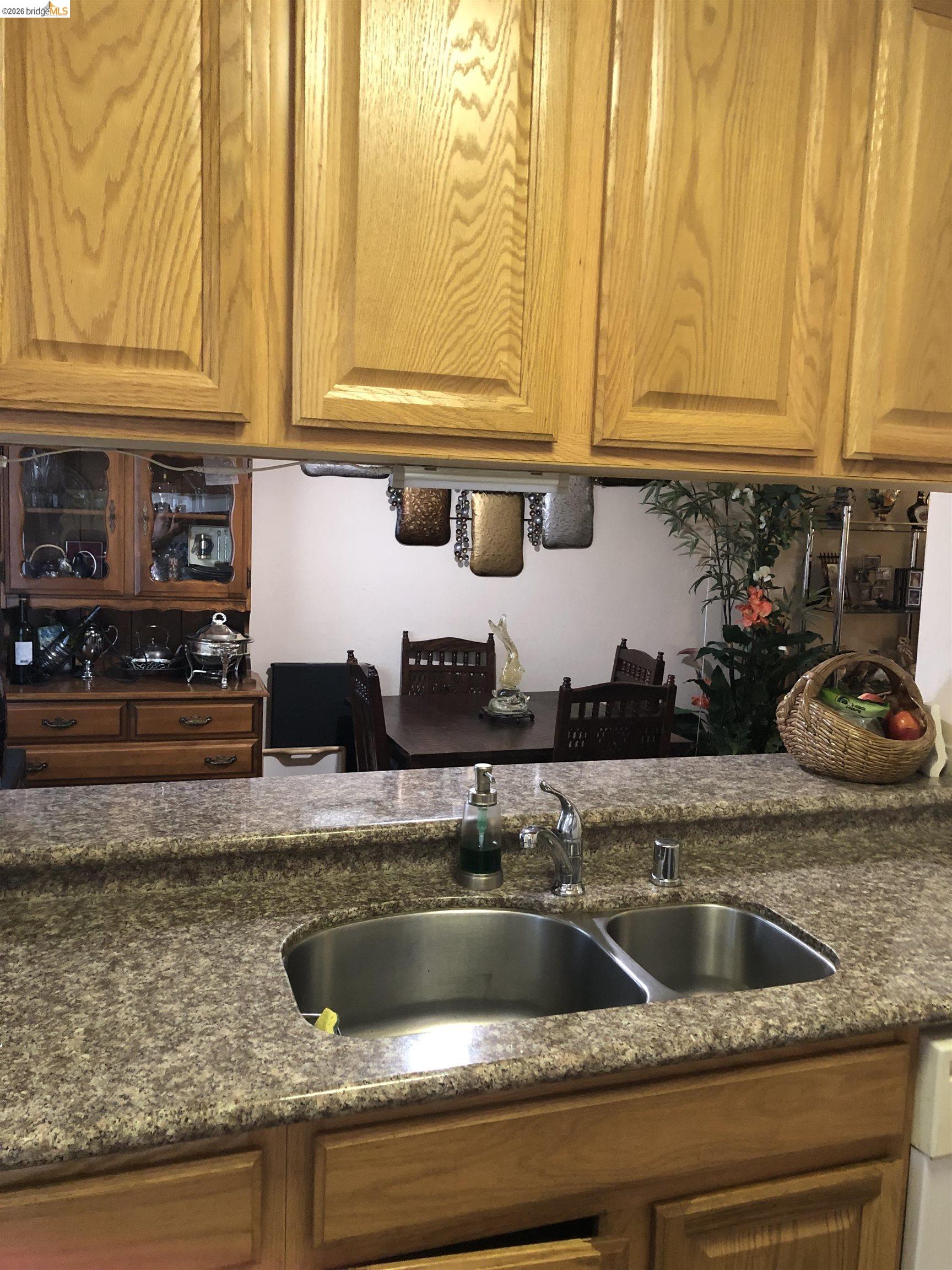 2089 Olivera Road, Unit B Concord, CA 94520 - Photo 4 of 8 Light wood-finish cabinetry, speckled countertop, and a double basin stainless steel sink with a chrome faucet