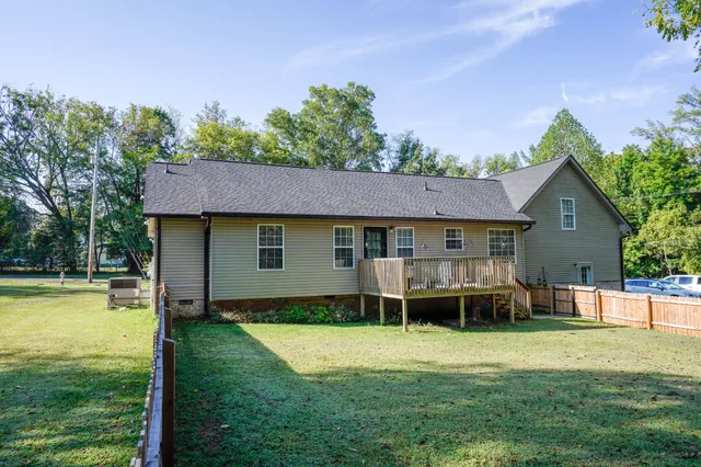 a view of a house with a yard patio and a swimming pool