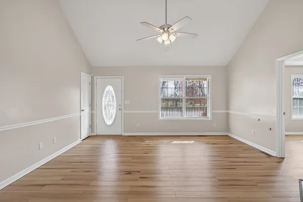 a view of an empty room with a window and wooden floor