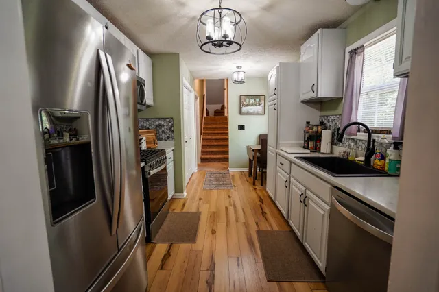a kitchen with stainless steel appliances a refrigerator a sink a stove and cabinets