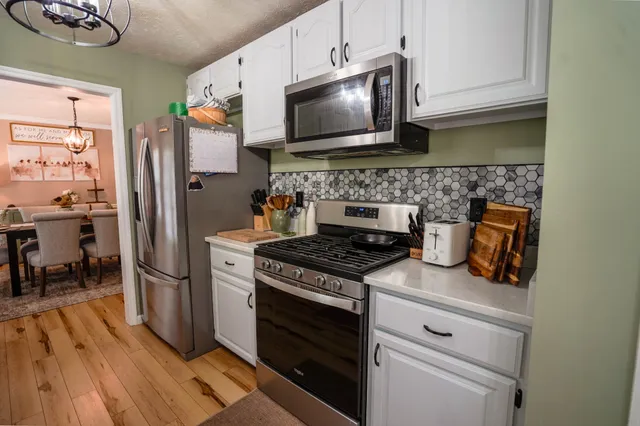 a kitchen with stainless steel appliances granite countertop a stove a refrigerator and a microwave