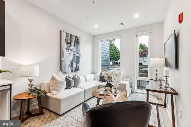a living room with furniture fireplace and large windows