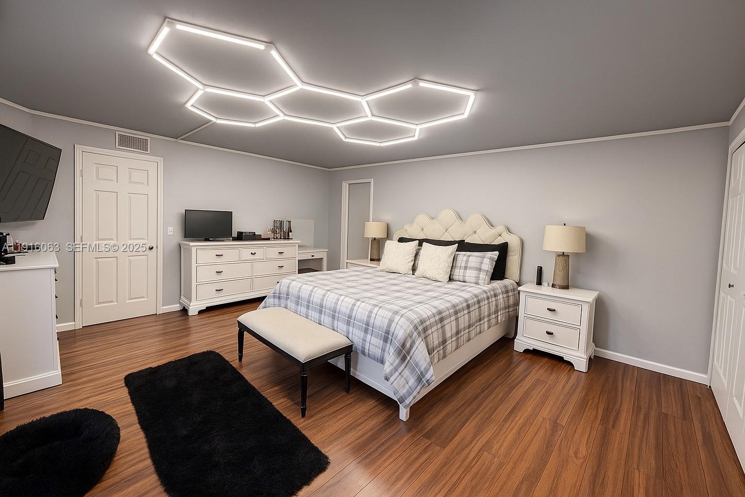 a bedroom with a bed and flat tv screen