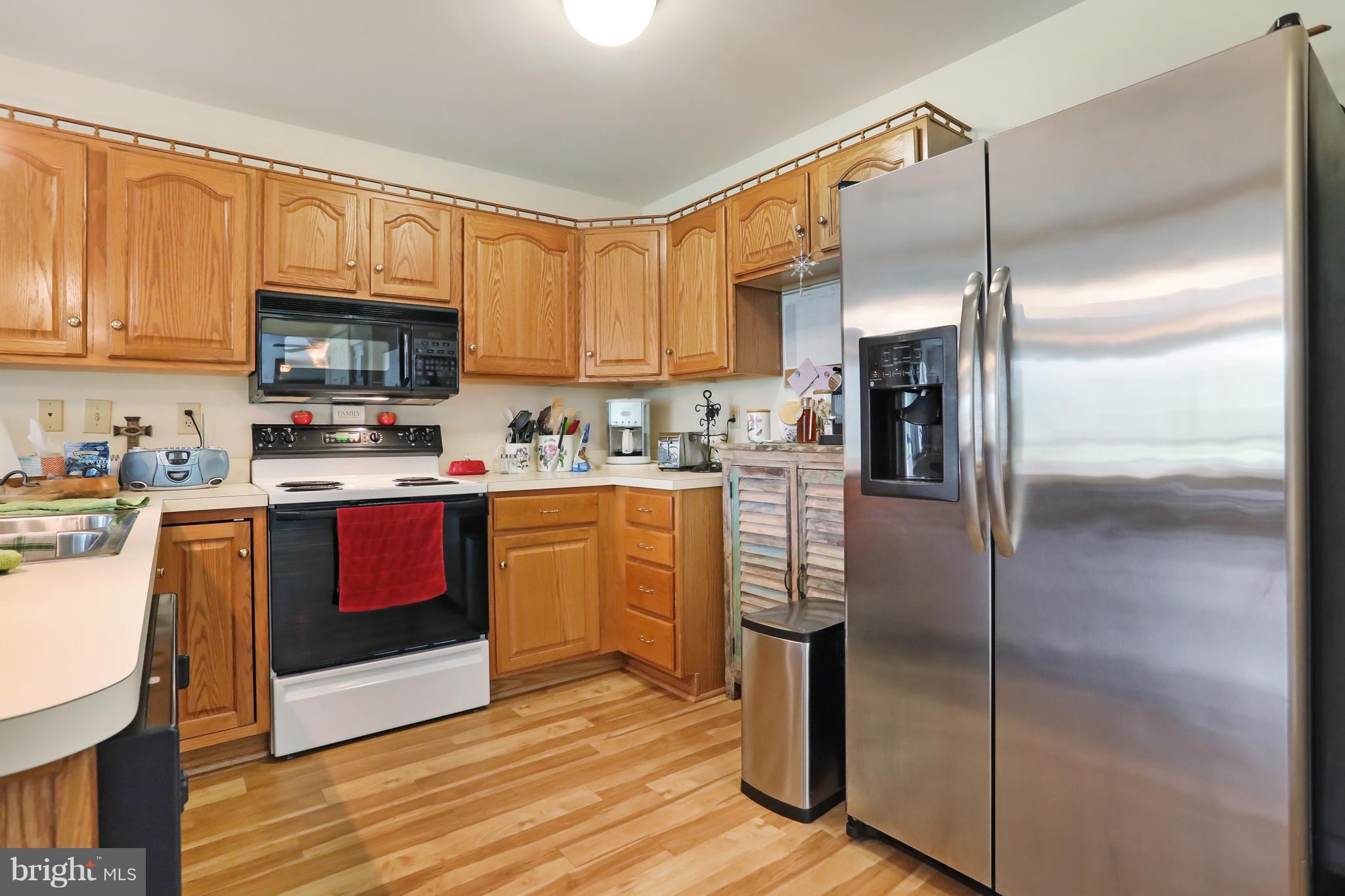 13816 Big Pool Road Clear Spring, MD 21722 - Photo 5 of 24 a kitchen with stainless steel appliances granite countertop a refrigerator a stove a sink and a microwave with wooden floor