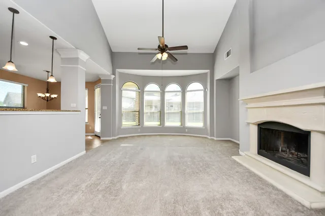 a view of an empty room with a fireplace and a window