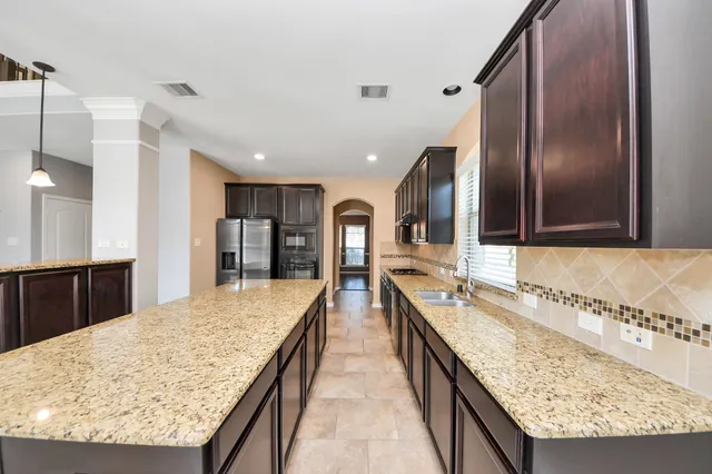 a large kitchen with kitchen island granite countertop a sink and counter space