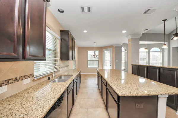 a large kitchen with granite countertop a large counter top stainless steel appliances and a counter space