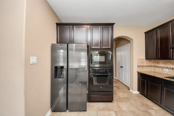 a kitchen with stainless steel appliances granite countertop a refrigerator and a stove
