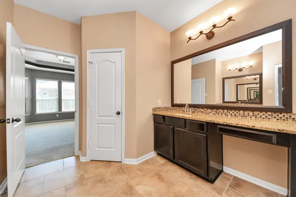 a bathroom with a granite countertop sink a mirror and a vanity
