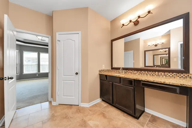 a bathroom with a granite countertop sink a mirror and a vanity