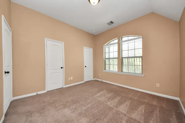 an empty room with windows and closet