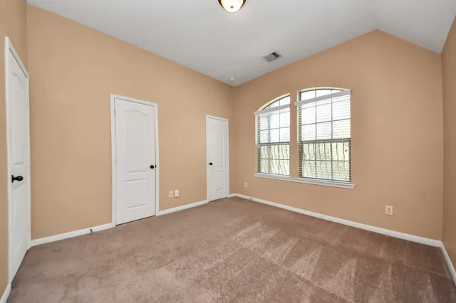 an empty room with windows and closet