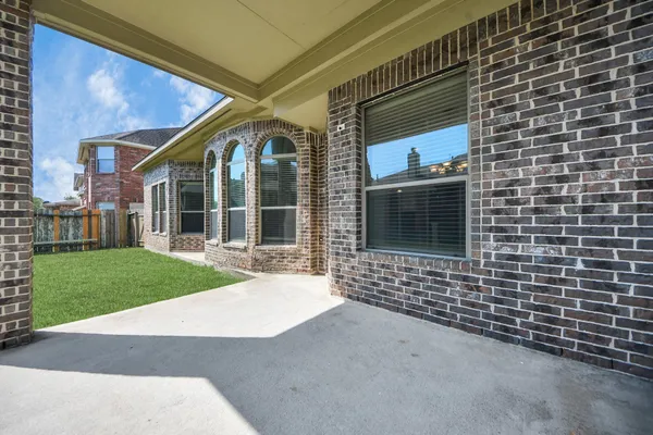 a view of a house with a big yard potted plants and a large window