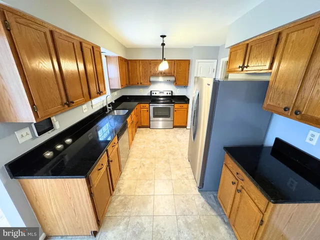 a kitchen with stainless steel appliances a stove a sink and a microwave