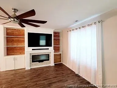 a view of an empty room with a fireplace and a window