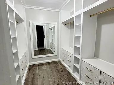 a view of an entryway with wooden floor and cabinet
