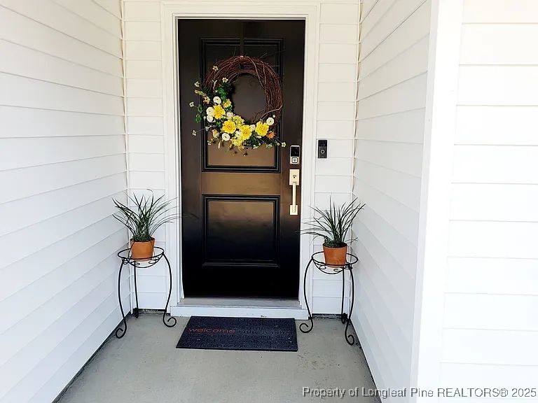 83 Kotata Avenue Bunnlevel, NC 28323 - Photo 3 of 17 a vase of flowers sitting on a floor in front of a door