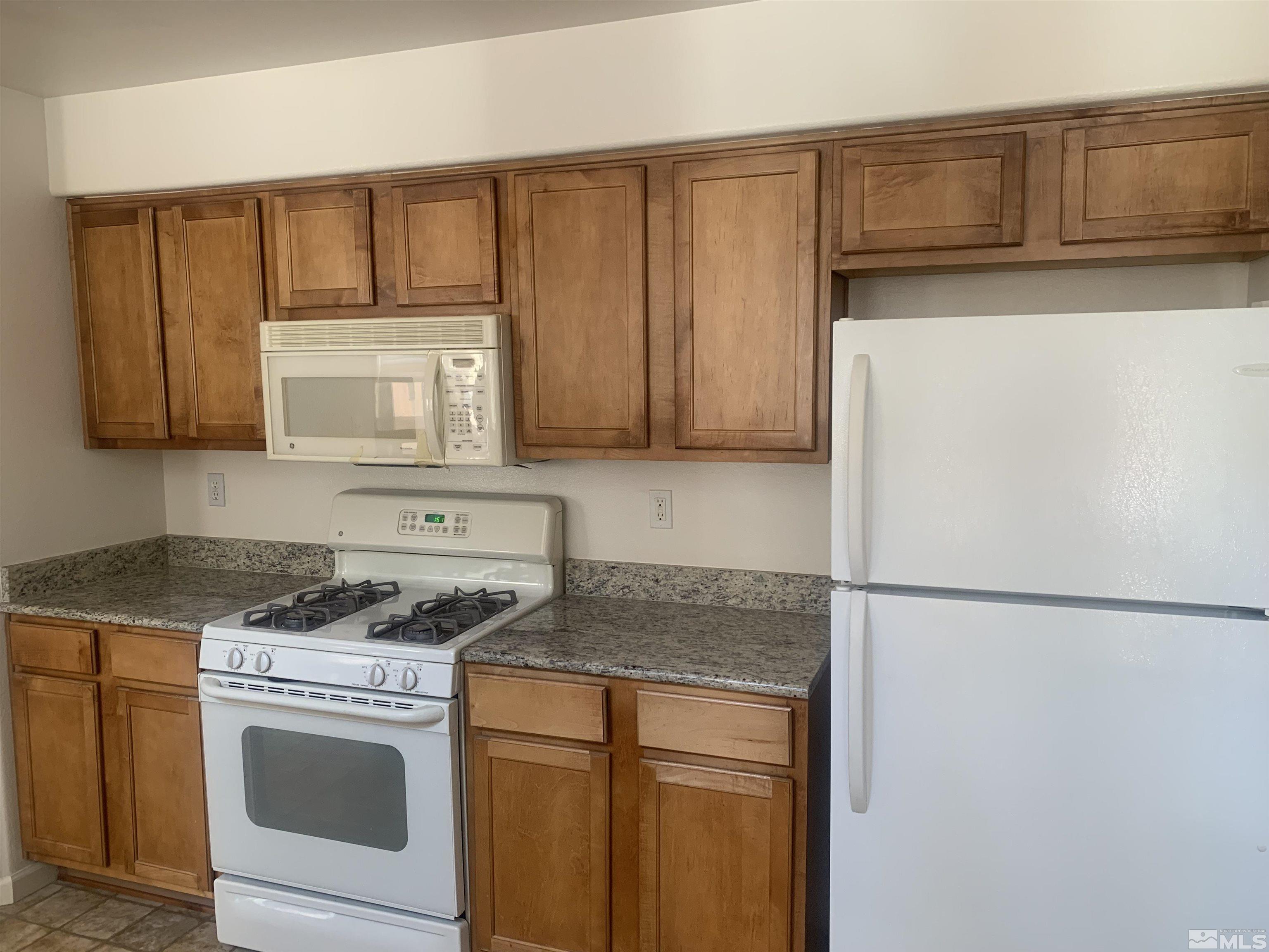 1325 South Meadows Parkway, Unit 422 Reno, NV 89521 - Photo 6 of 10 a kitchen with granite countertop cabinets stainless steel appliances and a counter space