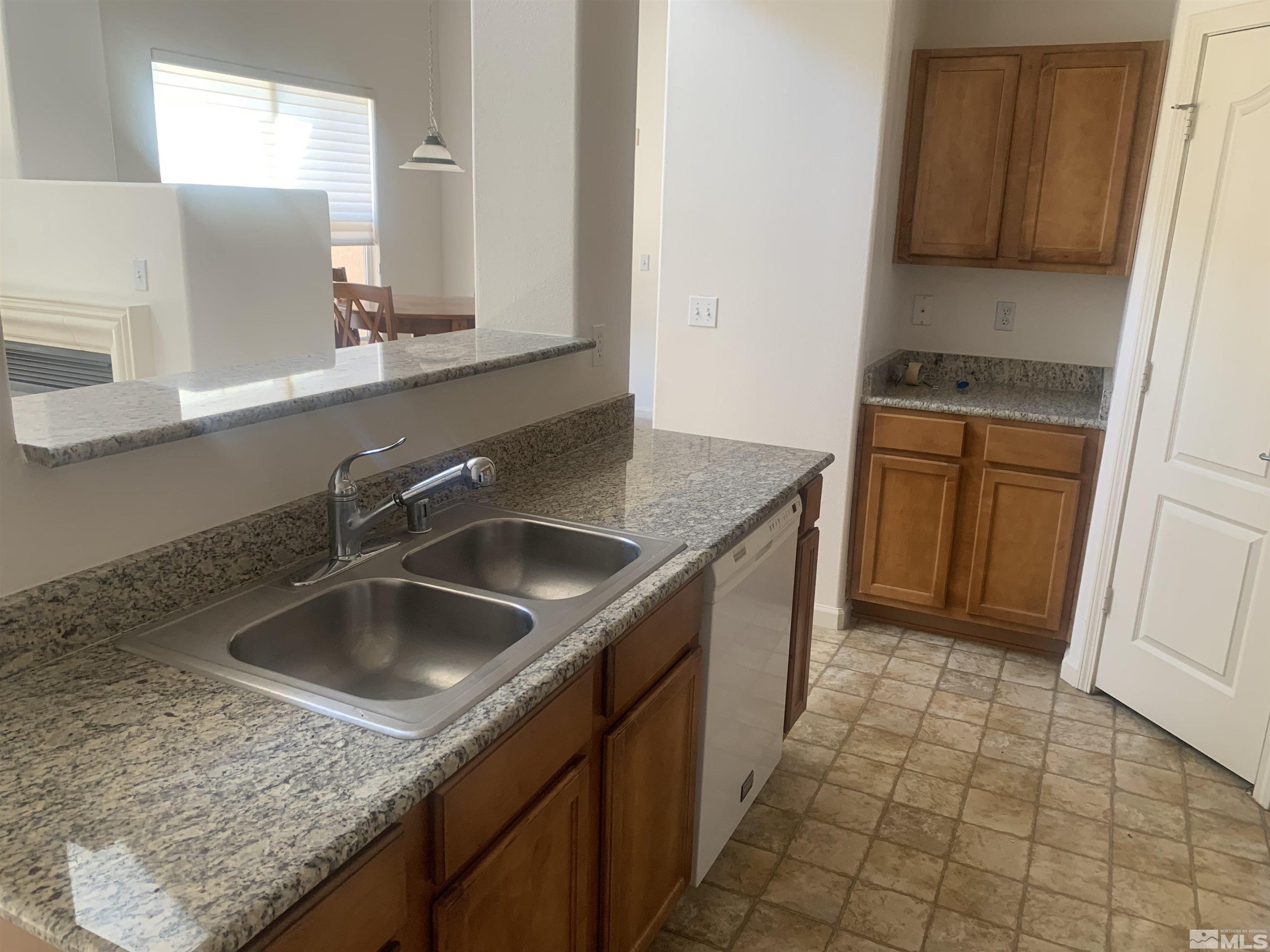 1325 South Meadows Parkway, Unit 422 Reno, NV 89521 - Photo 7 of 10 a kitchen with a sink a counter top space and cabinets