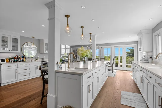 a large kitchen with stainless steel appliances kitchen island granite countertop a lot of counter space and wooden floors