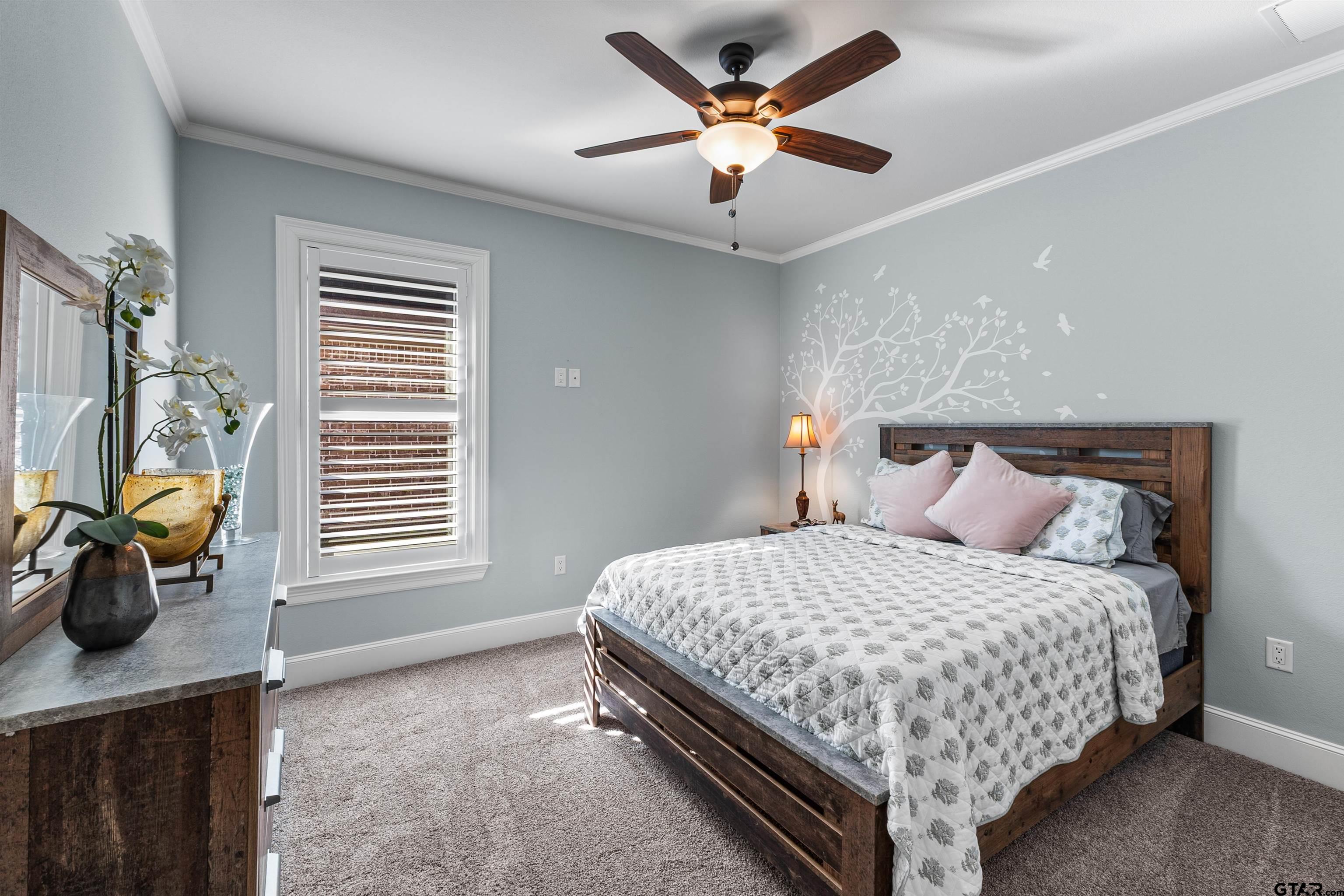 1111 Cambridge Bend Tyler, TX 75703 - Photo 22 of 42 a bedroom with a bed a chandelier and a window