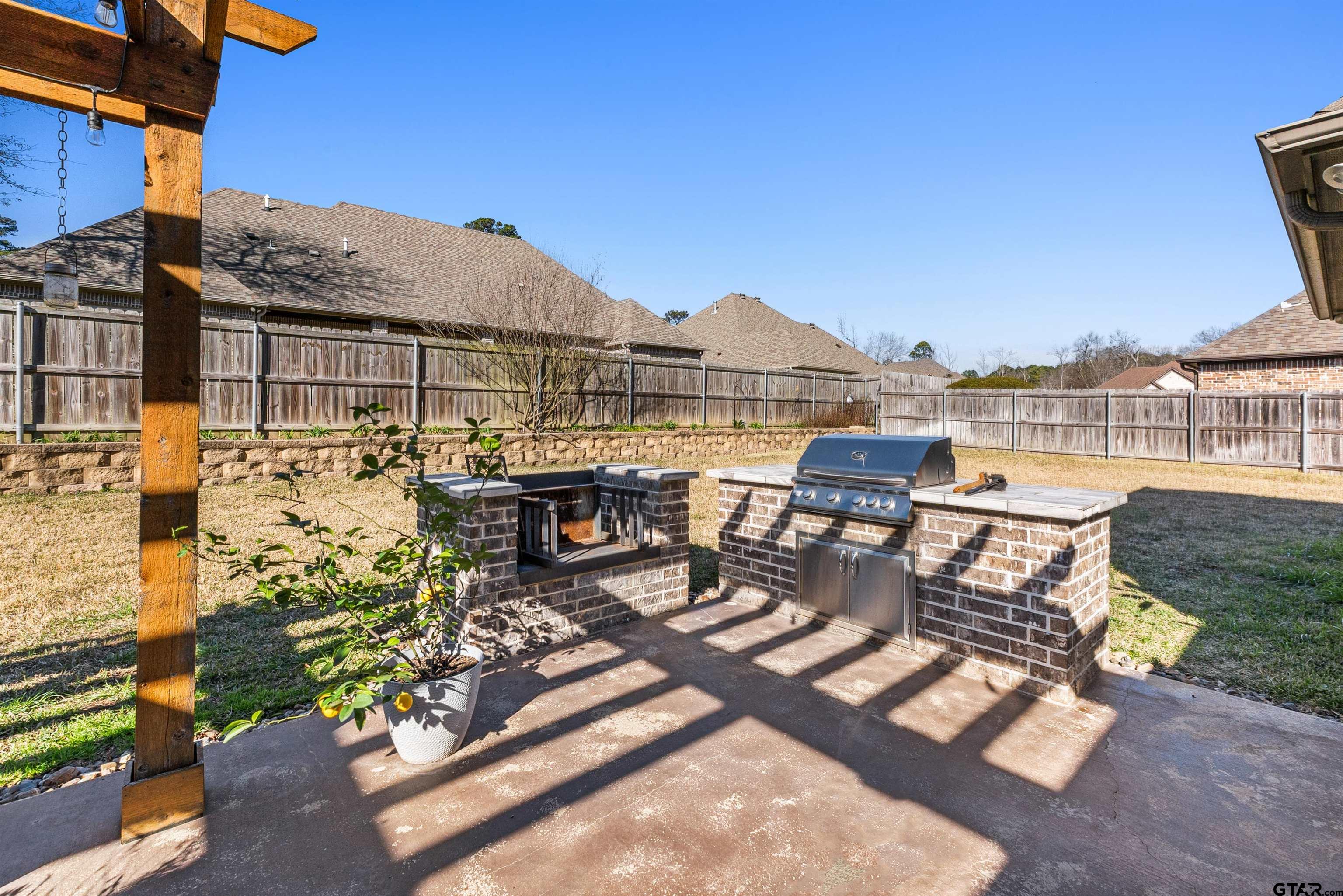 1111 Cambridge Bend Tyler, TX 75703 - Photo 39 of 42 a view of a patio with couches table and chairs under an umbrella next to a yard
