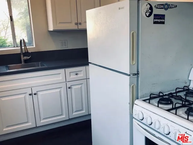 a kitchen with white cabinets and a sink