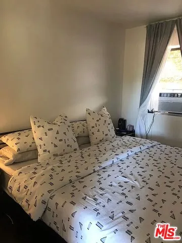 a bedroom with a bed and a painting on the wall