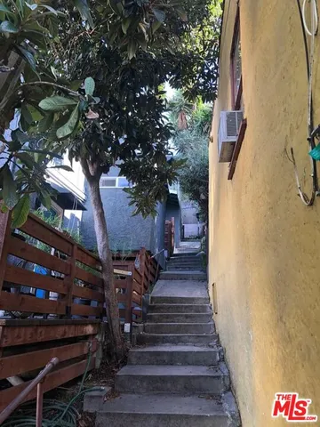 a view of a houses with a yard and potted plants