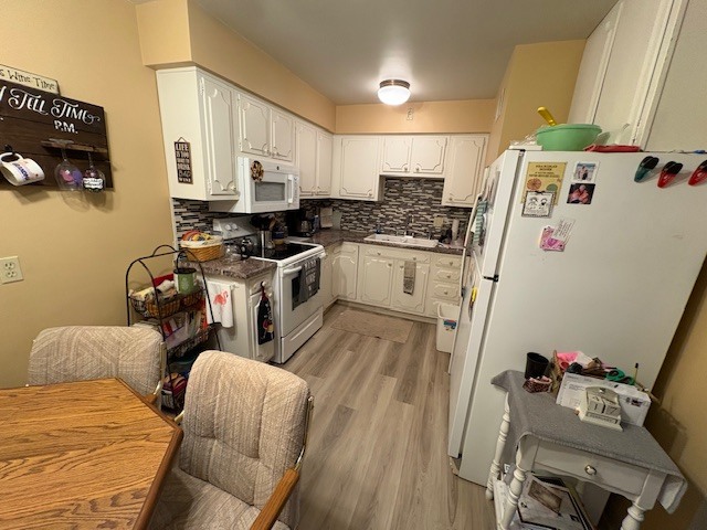 940 17th Street, Unit 7 Moline, IL 61265 - Photo 3 of 7 a kitchen with a refrigerator a stove a sink dishwasher and white cabinets with wooden floor