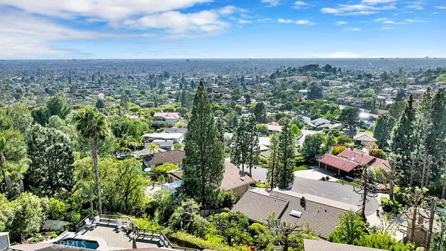 an aerial view of residential houses with outdoor space and trees