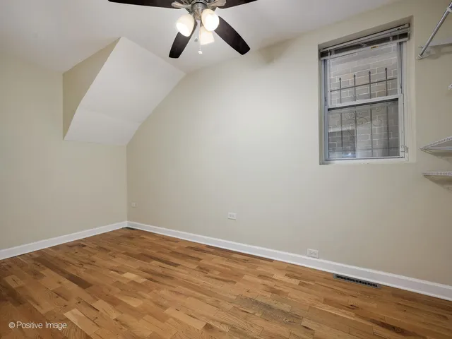 a view of an empty room with wooden floor and closet