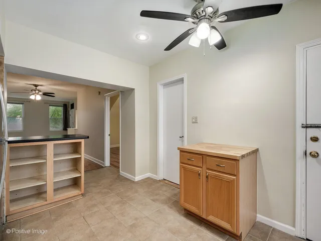 a view of an empty room with cabinet and a chandelier fan