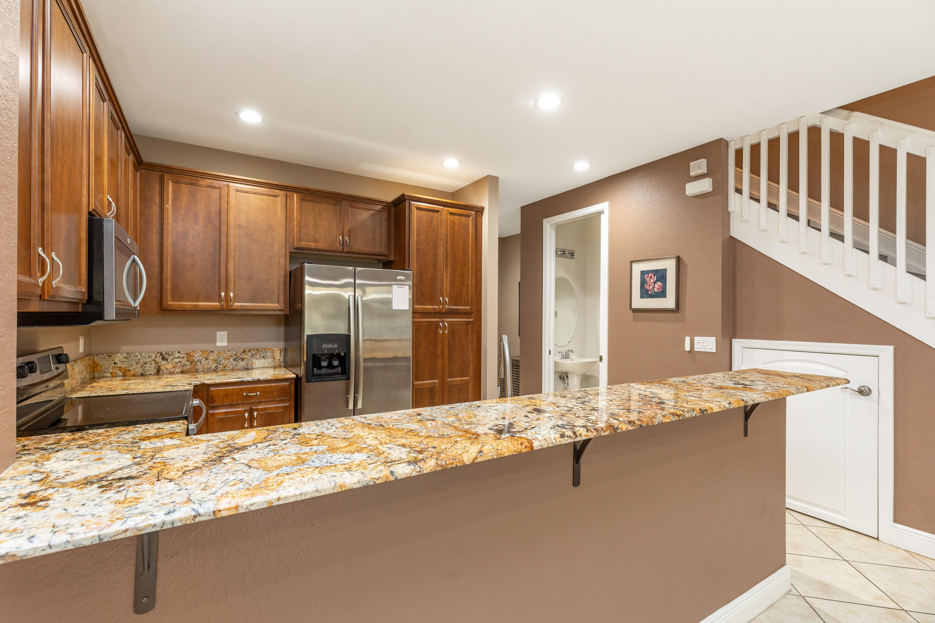 7782 Paddock Place Davie, FL 33328 - Photo 12 of 40 a kitchen with stainless steel appliances granite countertop a sink refrigerator and cabinets
